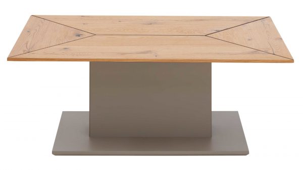 Der Interliving Wohnzimmer Serie 2022 - Couchtisch CT330-110 ist ein rechteckiger Holztisch mit einer geometrischen Platte aus hellem Holz, die von einem breiten, massiven grauen Sockel und einer passenden rechteckigen Plattform am Boden getragen wird.