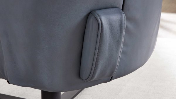Die Nahaufnahme des Interliving Sessels Serie 4561 - Akku-Überzug zeigt eine kleine rechteckige Tasche, die in die graue Polsterung eingenäht ist. Der Sessel steht auf einem hellen Boden.