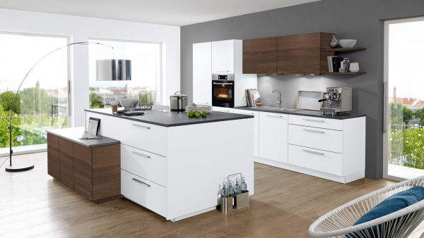 Moderne Küche mit weißen Schränken, dunklen Arbeitsplatten, Holzakzenten und Geräten aus Edelstahl. Große Fenster lassen natürliches Licht herein und betonen eine Insel mit Schubladen und einen Herd. Holzböden und Blick auf die Stadt draußen.