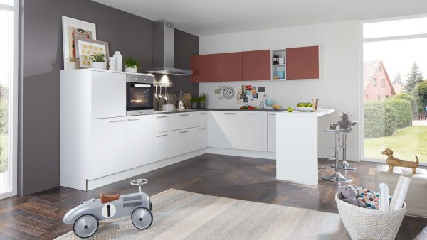 Moderne Küche mit weißen und braunen Schränken, Geräten aus Edelstahl und einer Frühstücksbar mit Hockern. Große Fenster lassen viel natürliches Licht herein. Ein Spielzeugauto, ein Korb mit Spielzeug und ein Hund stehen im Vordergrund auf einem Teppich.