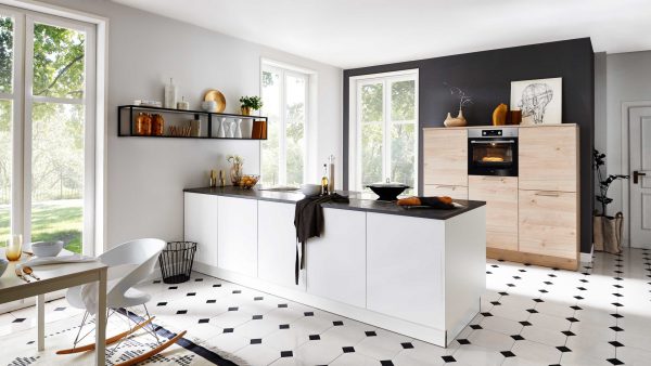 Moderne Küche mit weißen Schränken, schwarzen Arbeitsplatten, hellen Holzakzenten, offenen Regalen, eingebautem Ofen, großen Fenstern und schwarz-weißem Fliesenboden. Das Sonnenlicht strömt herein und schafft eine helle, luftige Atmosphäre.