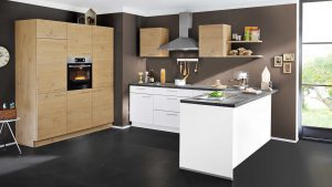 Moderne Küche mit hellen Holz- und weißen Schränken, Edelstahlgeräten, einem Wandbackofen, offenen Regalen, einer Dunstabzugshaube und großen Fenstern, die viel Tageslicht hereinlassen. Die Wände sind braun und der Boden ist dunkel.