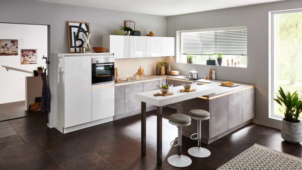 Moderne Küche mit weißen und grauen Schränken, Einbaubackofen, Bartheke mit zwei Hockern, großem Fenster mit Jalousien, Pflanzen und verschiedenen Küchenutensilien, die ordentlich auf Theken und Regalen angeordnet sind.
