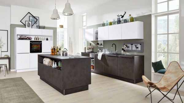 Moderne Küche mit weißen Oberschränken und dunklen Unterschränken, einer großen Insel mit offenen Regalen, Hängelampen und Dekorationsartikeln. Große Fenster lassen natürliches Licht herein und in der Ecke steht ein Schmetterlingsstuhl.
